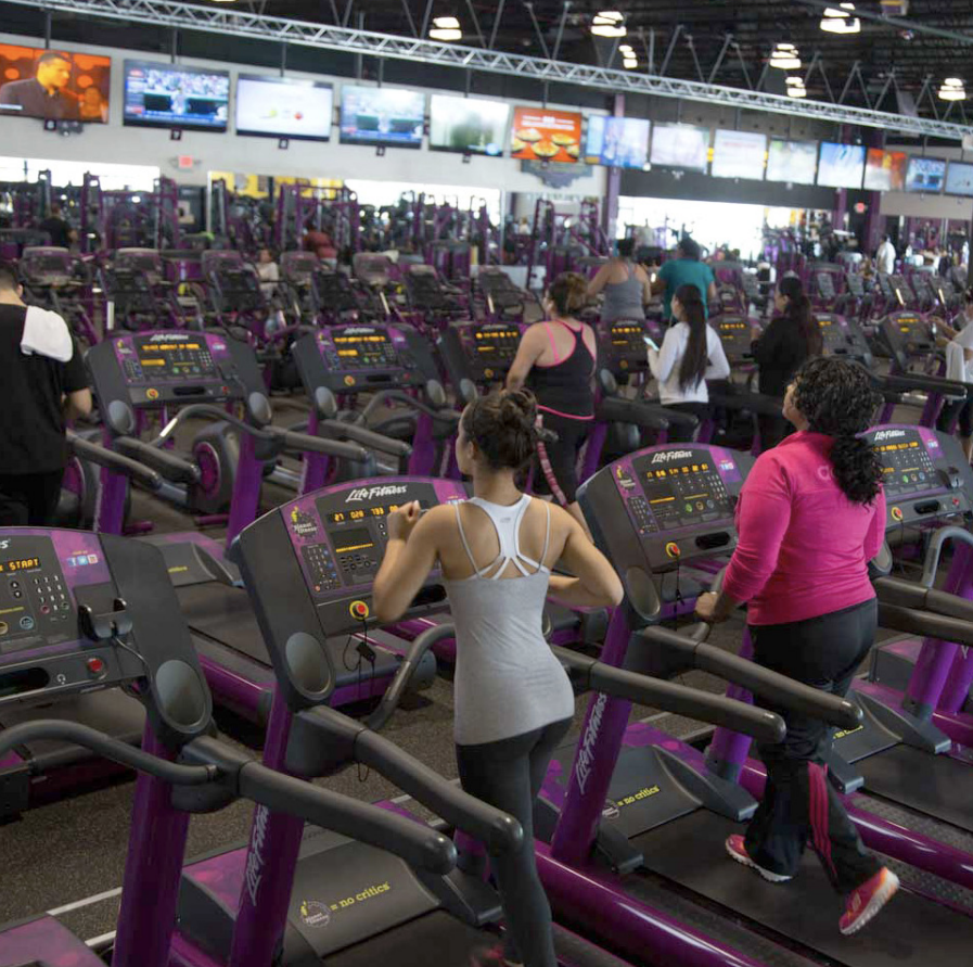 women run on treadmills at a Planet Fitness gym