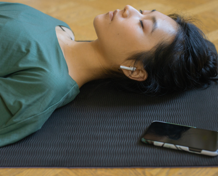 Woman lying on yoga mat eyes closed