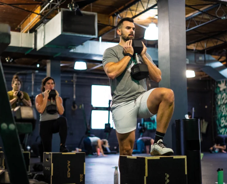 People doing step ups in a group strength training class.