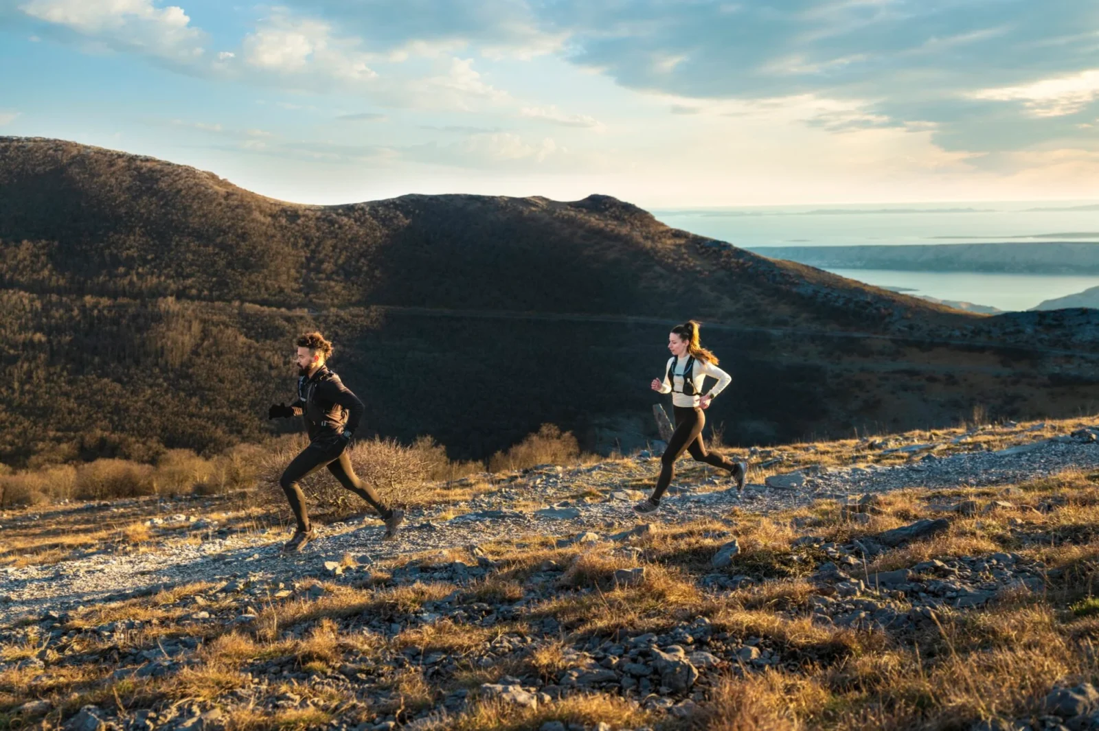 two people running along a scenic landscape