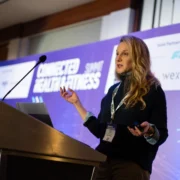 woman speaks at a podium at a fitness conference