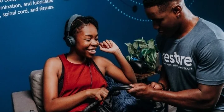 A black woman at Restore Wellness with a store employee