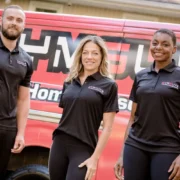 Three personal trainers standing in front of a mobile personal training van