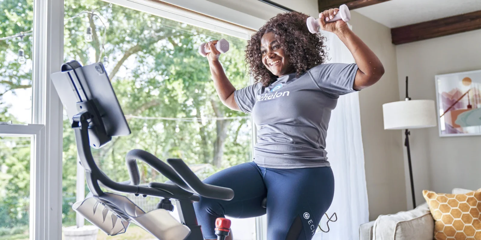 a smiling woman working out on Echelon fitness equipment