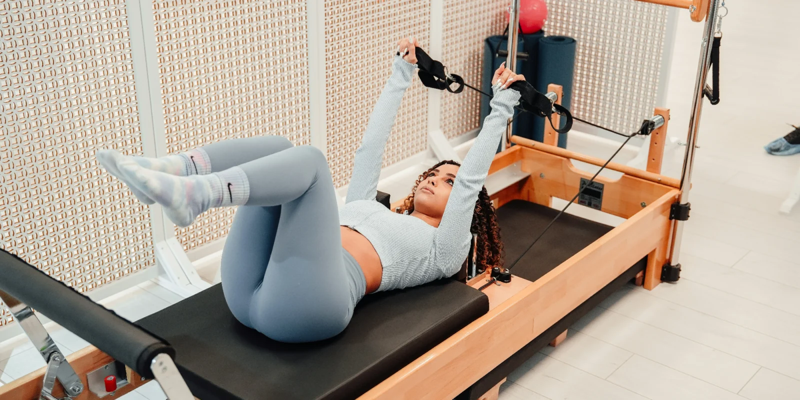 a woman working out on a Pilates reformer