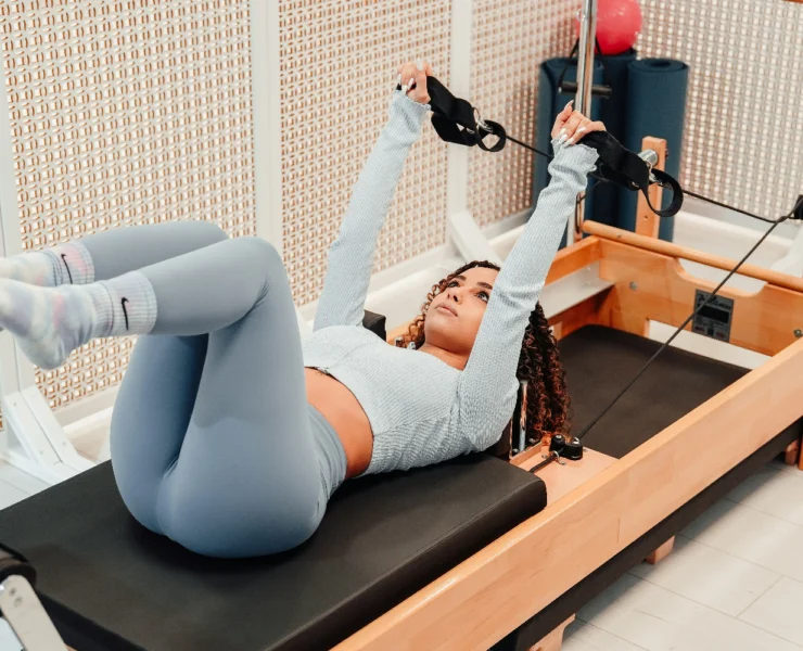 a woman working out on a Pilates reformer