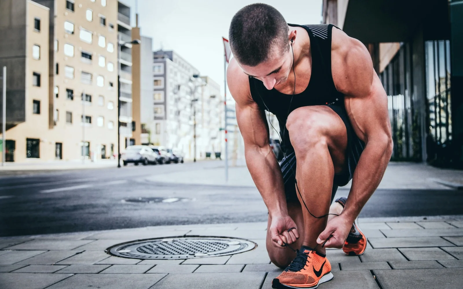 man in workout gear ties his shoes