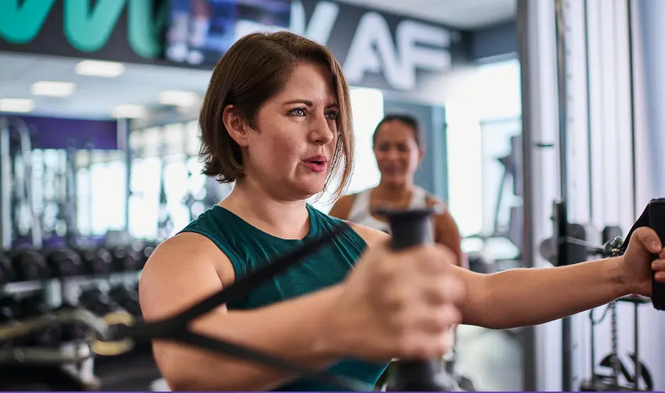 woman works out on a cable machine at Anytime Fitness