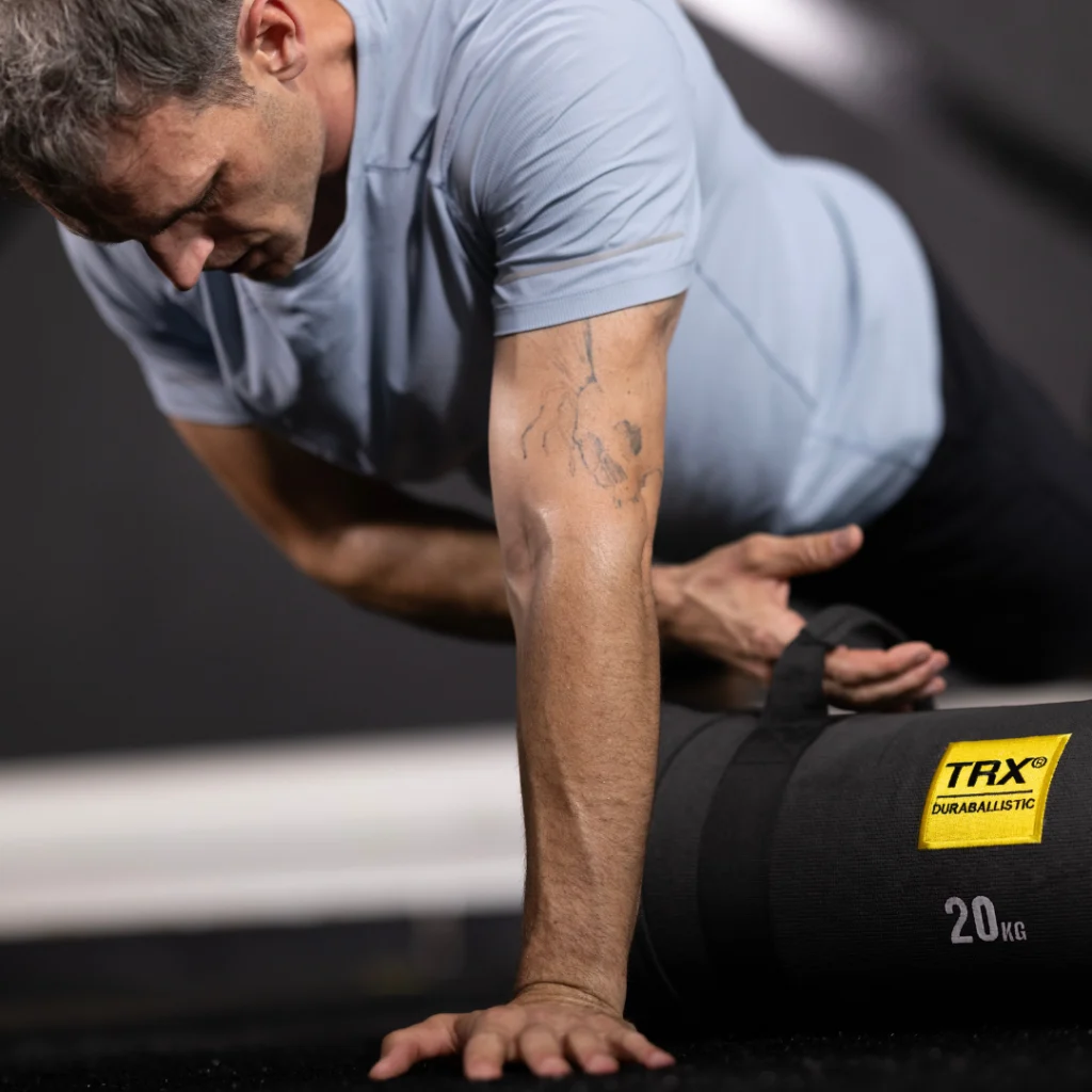 man works out with TRX bag