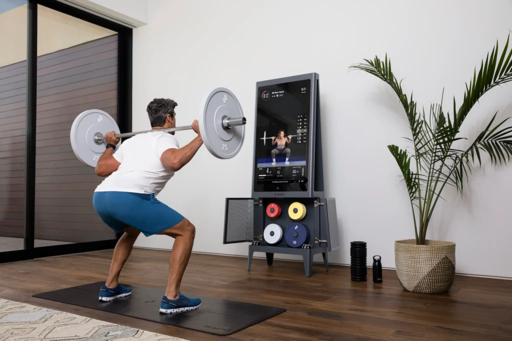 man performs a back squat using Tempo strength training equipment