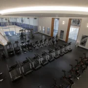 rows of fitness equipment overlook a basketball court