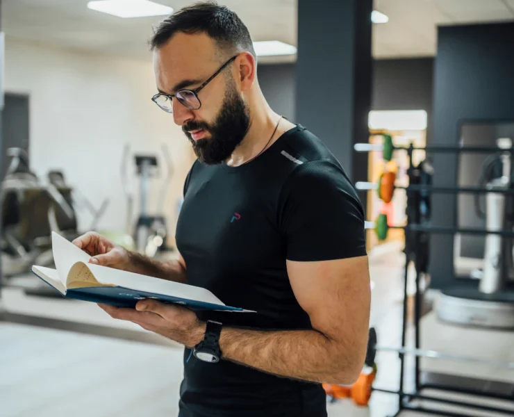 gym owner looking at book