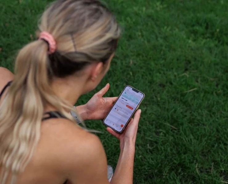 athletic woman looks at her smartphone