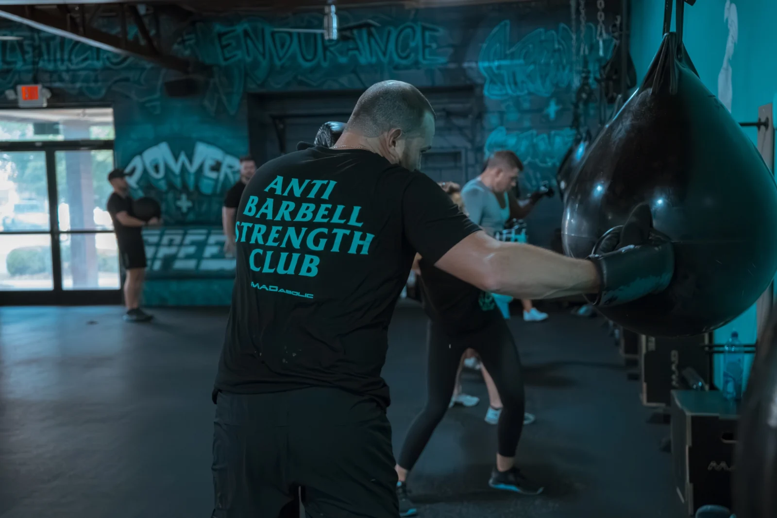 man hits a boxing bag inside a fitness studio