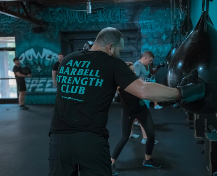 man hits a boxing bag inside a fitness studio