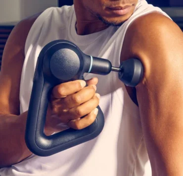 Man uses a Therabody massage gun