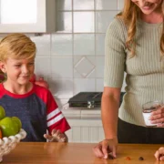 a smiling woman and young boy in the kitchen with supplements