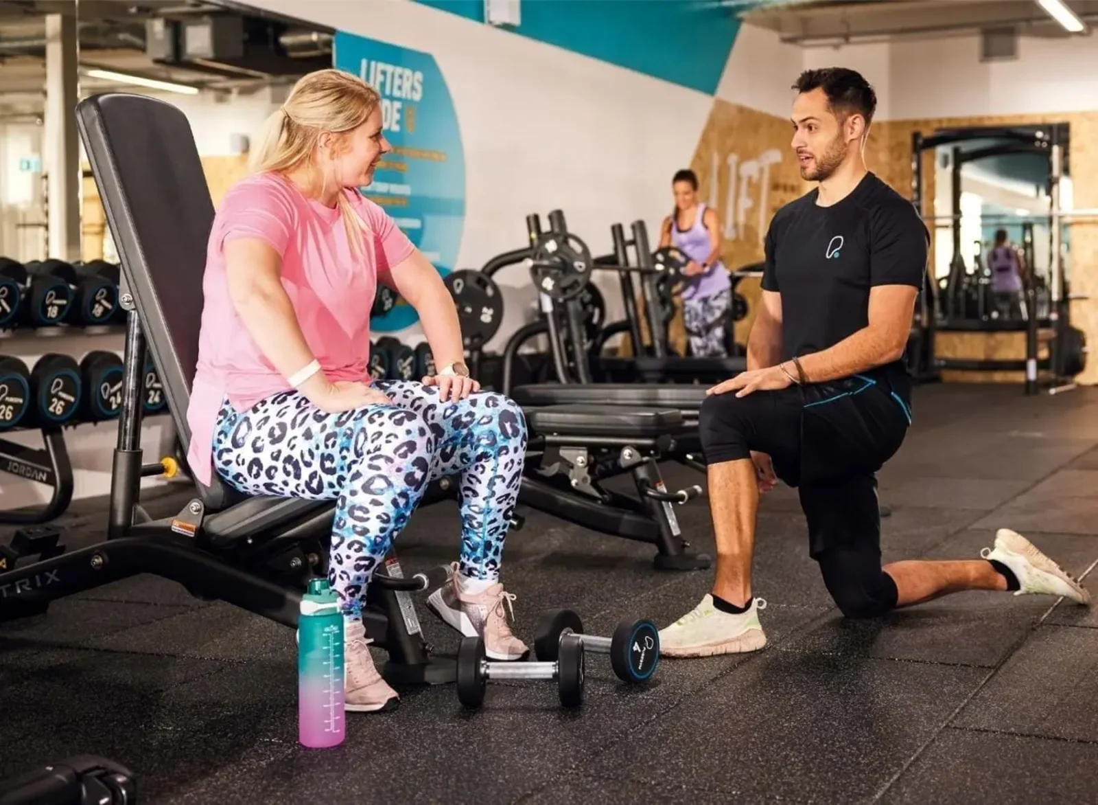 a PureGym member chats with a personal trainer