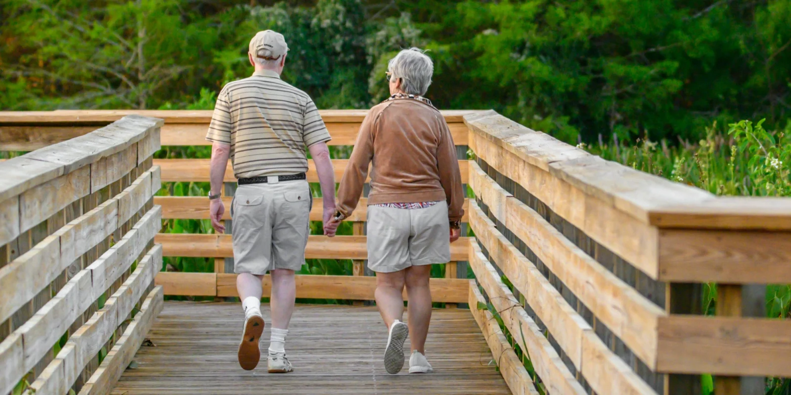 two seniors walking together hand in hand to get physical activity