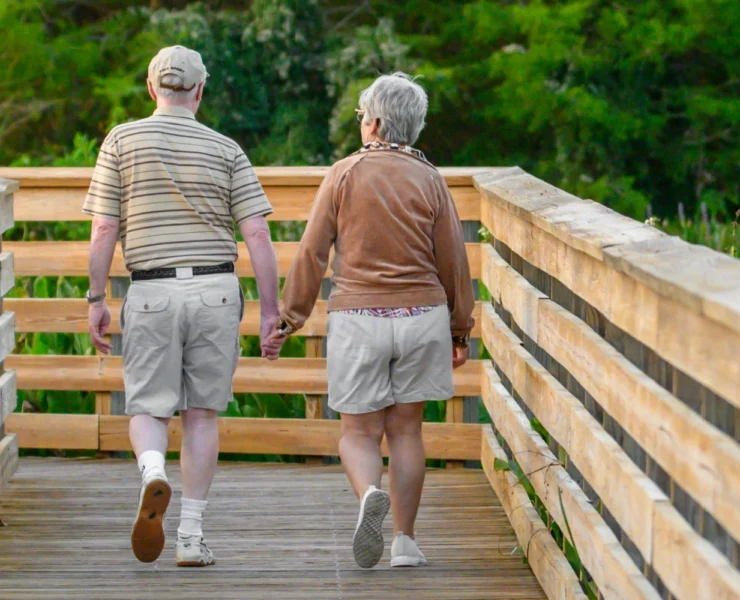 two seniors walking together hand in hand to get physical activity