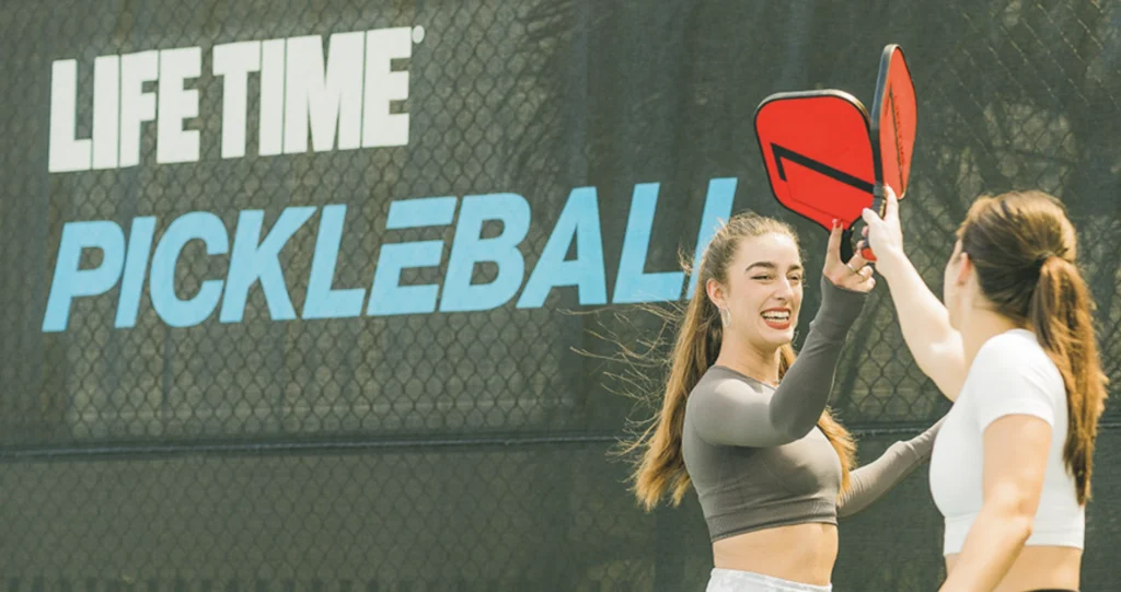 an image of two girls at a Life Time pickleball court