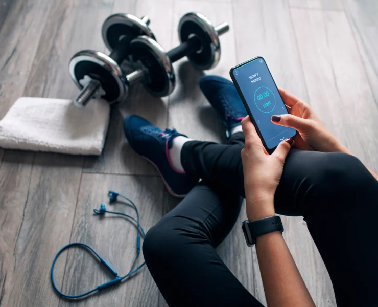 woman looks at a fitness app before working out