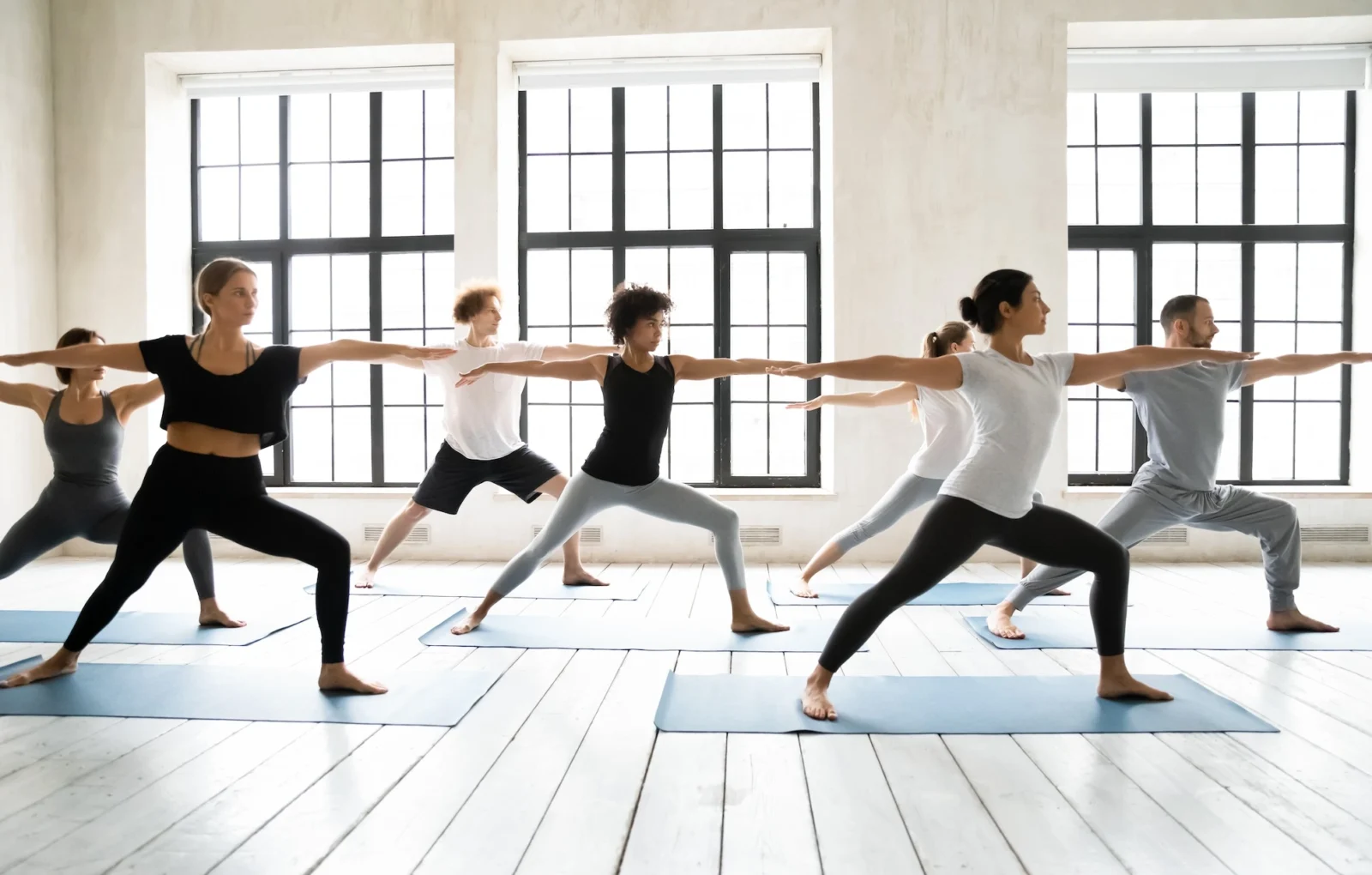 men and woman pose during a yoga class