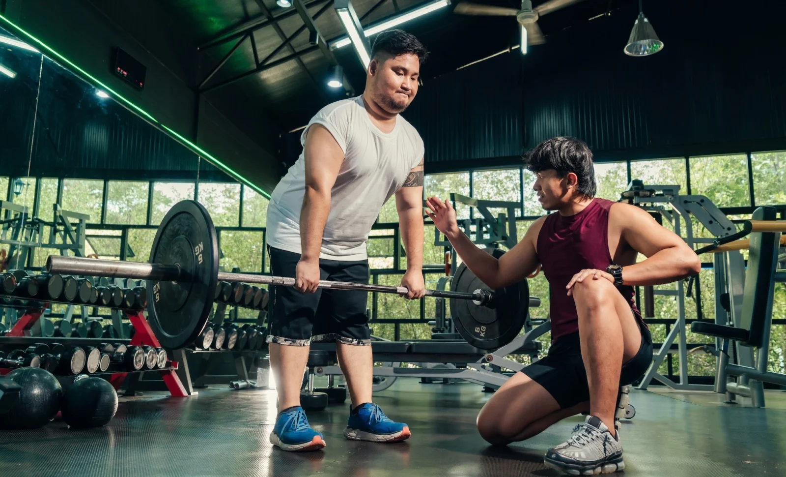 overweight man works out with help from a personal trainer