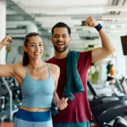 man and woman pose together inside a gym after working out