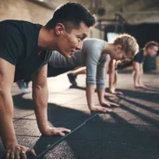 men and women perform planks inside a gym