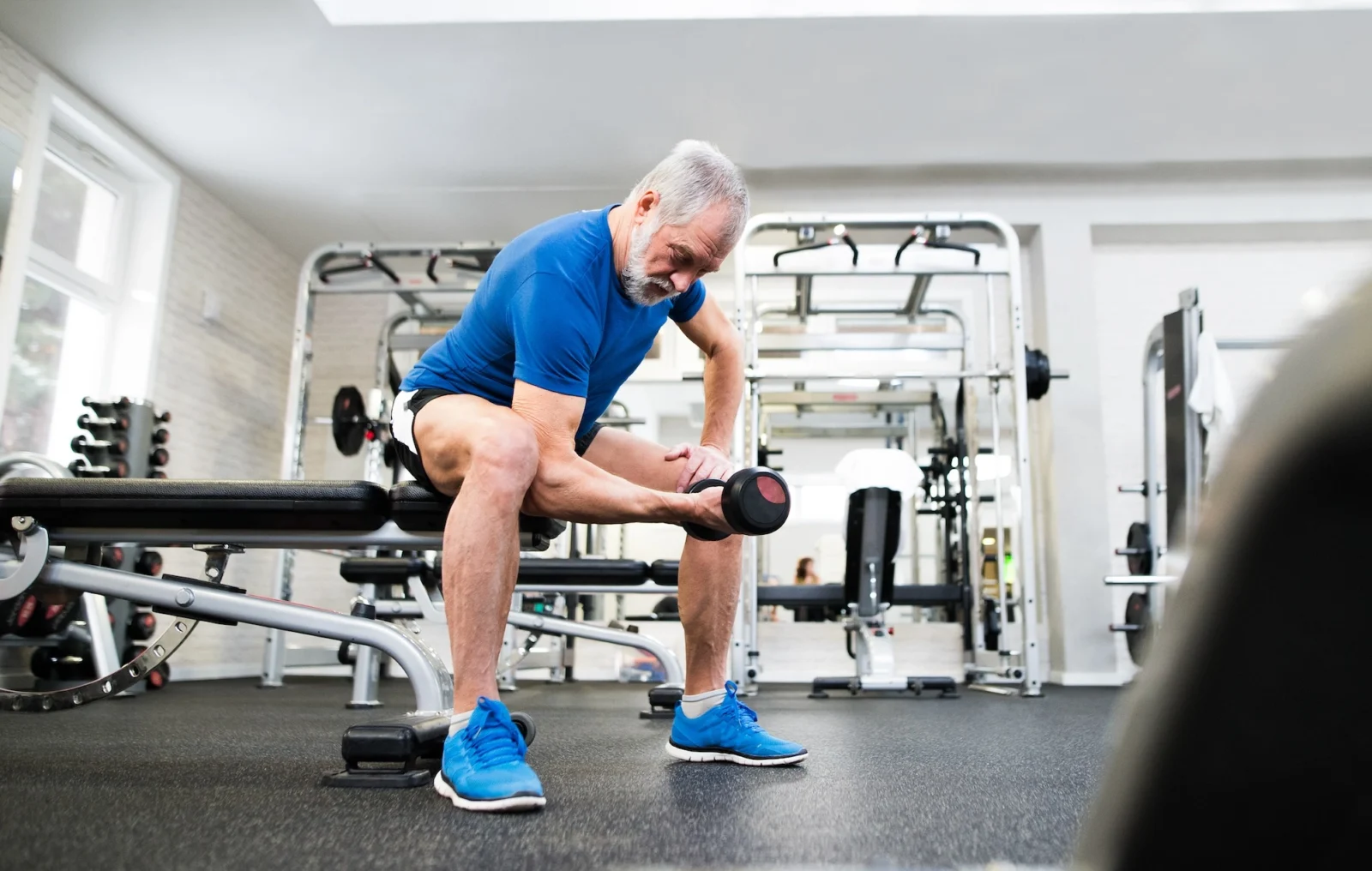 older man works out inside a gym