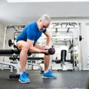 older man works out inside a gym