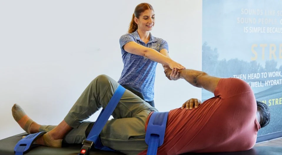 Woman Stretching man at Stretch Zone