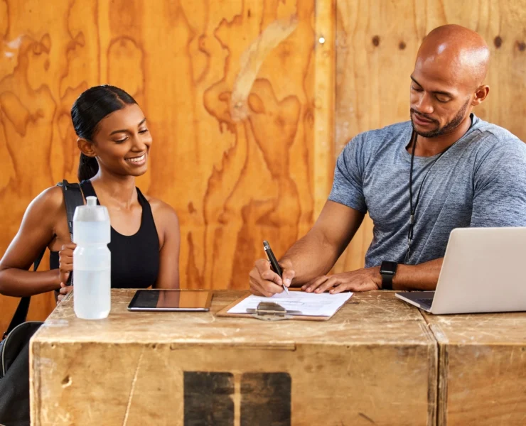 man and woman stand behind a gym desk