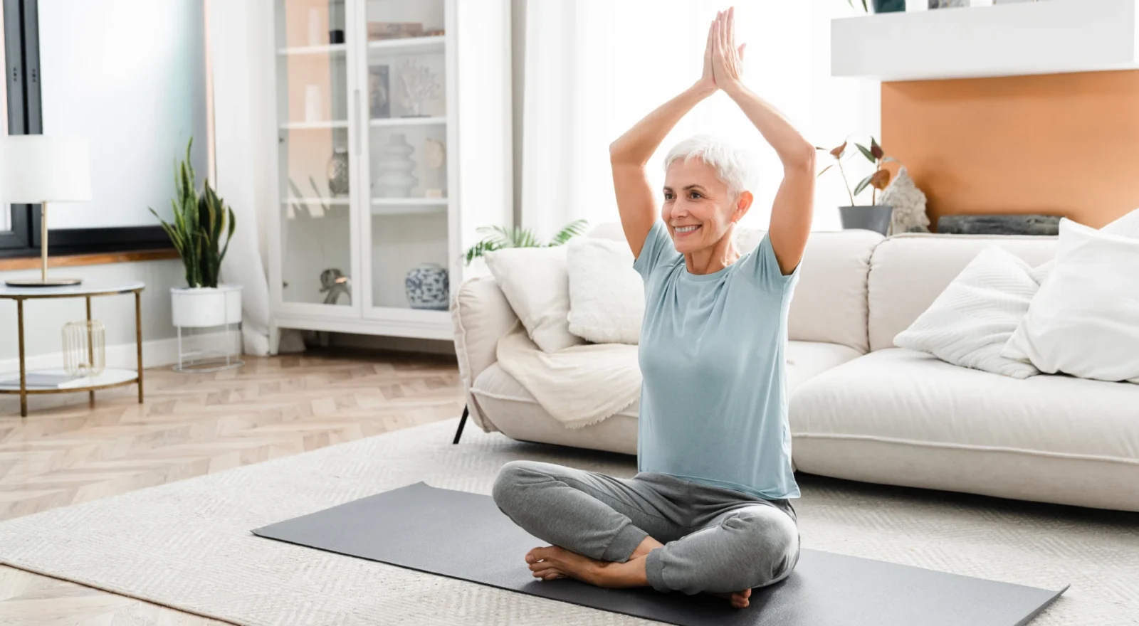 older woman doing yoga at home